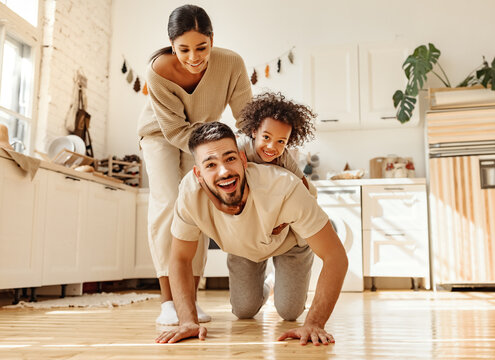 Happy Multiracial Family Playing In Kitchen.