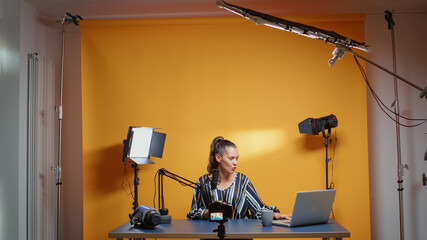 Influencer in her professional studio recording a new episode for subscribers. Backstage of content creator new media star on social media for internet web online audience podcast episode microphone