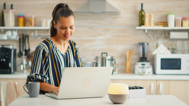 Working in the kitchen with essential oils diffuser steaming. Aroma health essence, welness aromatherapy home spa fragrance tranquil theraphy, therapeutic steam, mental health treatment