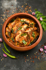 Top view of Sardine fish curry spicy Kerala fish curry India, Indian food. Fish curry with red chili, curry leaf. Asian cuisine. Delicious spicy, Bengali Goan fish curry coconut milk, mango clay pot.