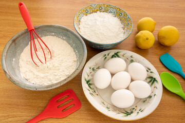 Baking Cooking Ingredients Flour Eggs colorful Kitchen utensils On Bright woody Background. Top View Copy Space. Cookies Pie Or Cake Recipe.