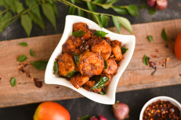 Top view spicy hot Bengali Prawn roast , shrimp masala fish curry. Indian food. Fish fry with red chili, curry leaf. Asian cuisine. Delicious Kerala, Goan fish curry clay pot. Grilled tiger shrimps 