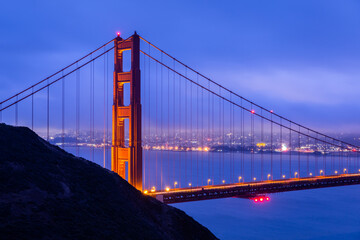 Golden gate with blue overcast sky at dawn.