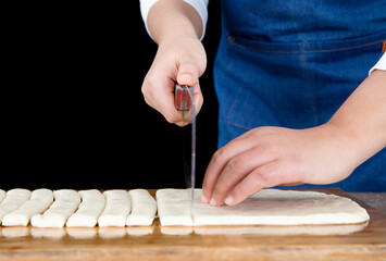 The chef cut the pie-shaped fried dough noodle into long strips with a knife