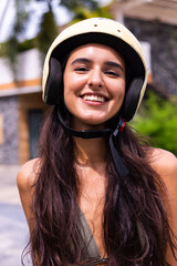 Fototapeta na wymiar Happy caucasian tanned woman with motorbike wearing helmet outdoor, sunny day, tropical background. 