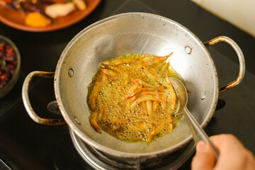 Top view of spicy hot anchovy fry in coconut oil Kerala fish curry. Indian food. Fried golden anchovies red chili powder, curry leaf. Asian cuisine. Delicious Bengali , Goan fish curry in clay pot