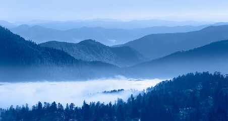 Naklejka na ściany i meble Beautiful landscape with cascade blue mountains at the morning - View of wilderness mountains during foggy weather