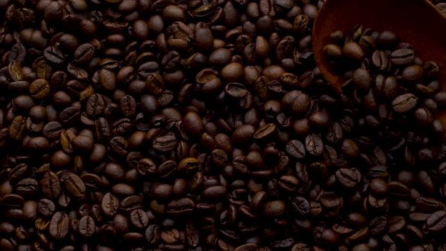 4K Footage. 4096x2304P.Fragrant coffee beans are roasted in a frying pan, smoke comes from coffee beans. The whole composition scrolls slowly around the camera. Scoop stir coffee beans.