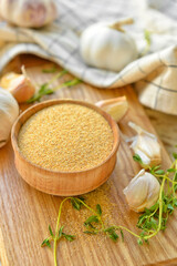 Bowl with aromatic powdered garlic on table