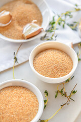Bowls with aromatic powdered garlic on table