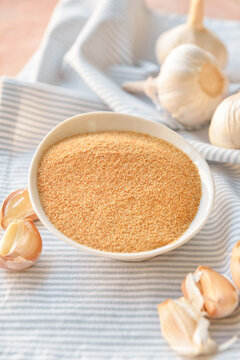 Bowl with aromatic powdered garlic on table