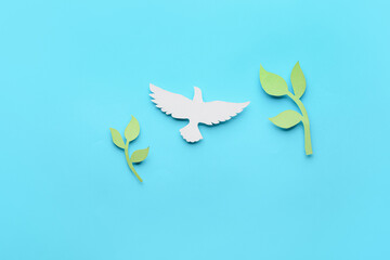 Paper dove and olive branches on color background. International Day of Peace