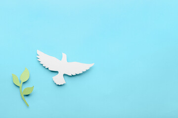 Paper dove and olive branch on color background. International Day of Peace