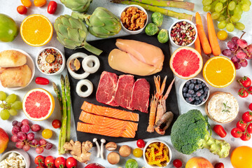 Various food products, shot from the top. Meat and fish, poultry, seafood, cheese, fruit, vegetables, nuts, legumes, mushrooms. A flat lay the concept of a balanced diet