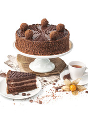food photography of homemade chocolate truffle cake side view on a ceramic stand, on white background isolated