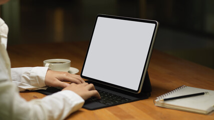 Fototapeta na wymiar Female typing on tablet keyboard include clipping path on table
