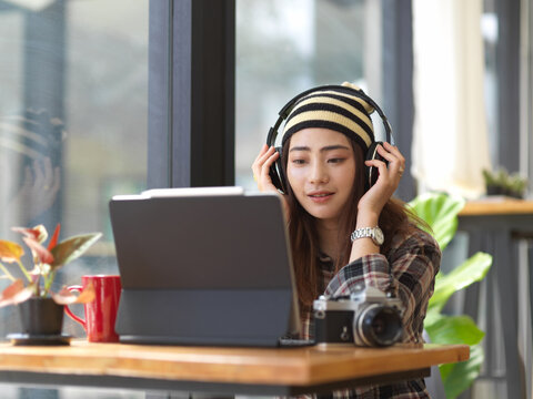 Female photographer listening to the music through headphones