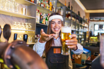 Bartender with face shield covid-19 protection, serving a draft beer at the bar counter during coronavirus pandemic, shelves full of bottles with alcohol on the background