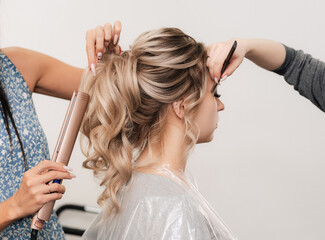 a hairdresser and a make-up artist simultaneously do their hair and make-up in a professional salon