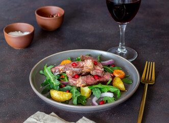 Grilled beef steak salad with arugula, potatoes, carrots, onions and pomegranate. Healthy eating. Diet.