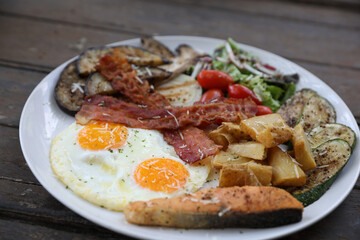American breakfast with egg bacon sausage and salad