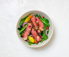 Grilled beef steak salad with arugula, potatoes, carrots, onions and pomegranate. Healthy eating. Diet.