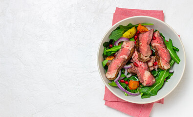 Grilled beef steak salad with arugula, potatoes, carrots, onions and pomegranate. Healthy eating. Diet.