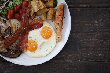 American breakfast with egg bacon sausage and salad