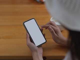 Female using smartphone include clipping path on wooden table