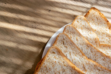 sliced whole grain, whole wheat  bread on the white plate under the morning light