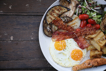 American breakfast with egg bacon sausage and salad
