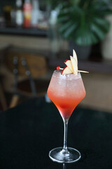 Pink Cocktail glass with ice at a bar counter