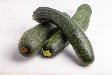 a group of green zucchini on a white wooden table