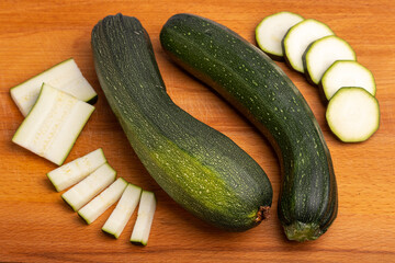 green sliced zucchini on a wooden cutting board