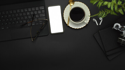 Workspace with smartphone, keyboard, camera, coffee cup and supplies, clipping path
