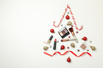 Christmas tree made of cosmetics and baubles on white background