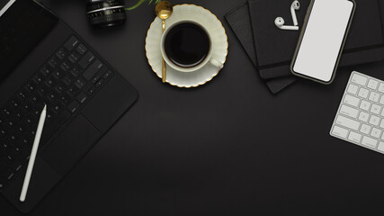 Black table with smartphone, keyboard, camera, coffee cup and supplies, clipping path