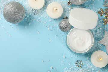 Jar of cosmetic cream and Christmas accessories on blue background