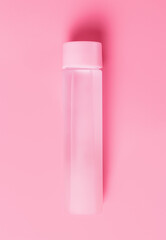 Water bottle on pink background copy space, top view