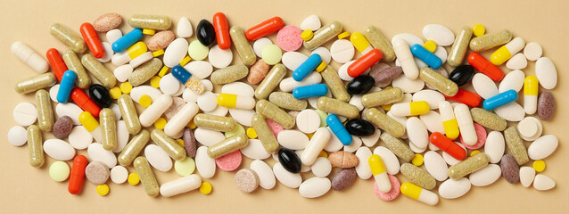 Different pills on beige background, top view
