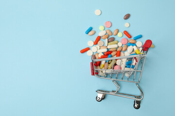 Shop cart with different pills on blue background