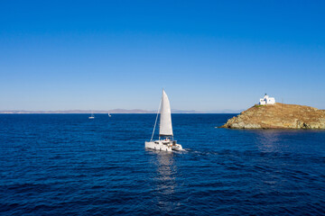 Fototapeta premium Sailing boat catamaran with white sails, rippled sea background