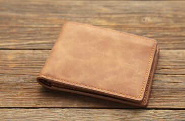 Brown shiny wallet on grey wooden background