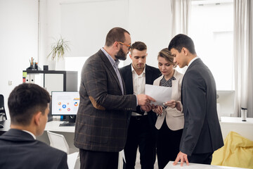 Senior managers and interns hold a meeting in the white office of the HR company. Open space zone....