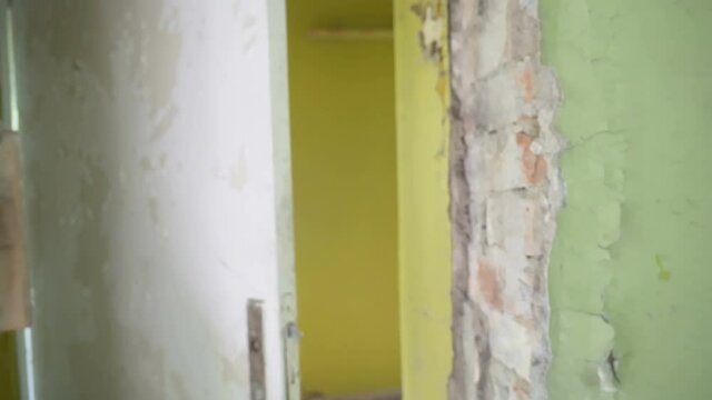 The yellow paint of the wall of the abandoned house