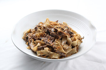 Pasta fettucine with mushrooms and creamy pesto sauce . Traditional italian food. Pasta with champignons, pesto and thyme. Copy space, side view