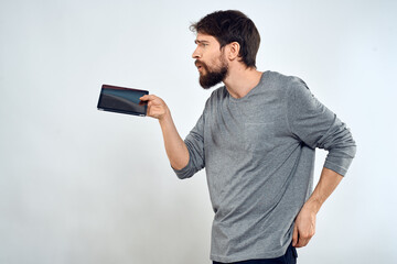 A man with a tablet in his hand internet technology communication gray jacket light background