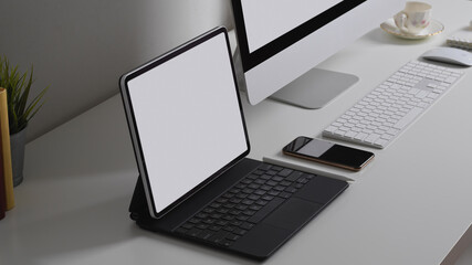 White table with tablet, computer and office supplies in office room, include clipping path