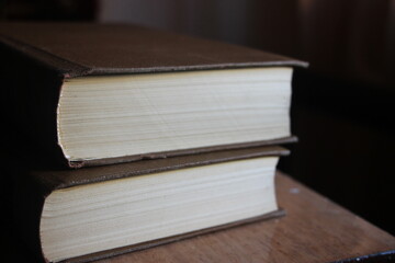 two old books lying on old wooden table - shallow depth of field