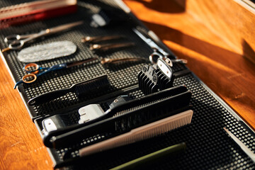 Fototapeta na wymiar Barber scissors and combs on black rubber mat